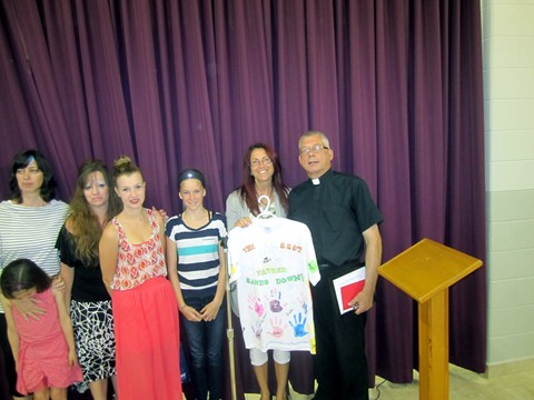 Members of the Children's Liturgy Group present  Father Michael with a specially decorated T shirt